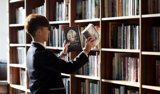 student putting books back on the shelves