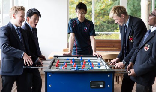 3 students playing foosball