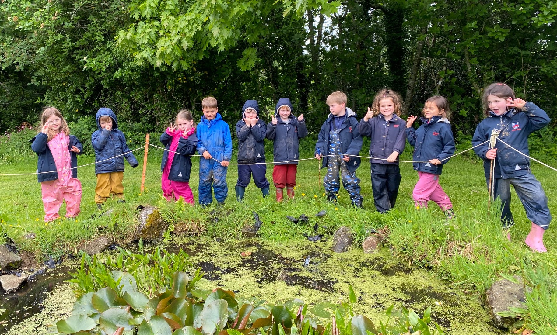 Students stood all around a pond