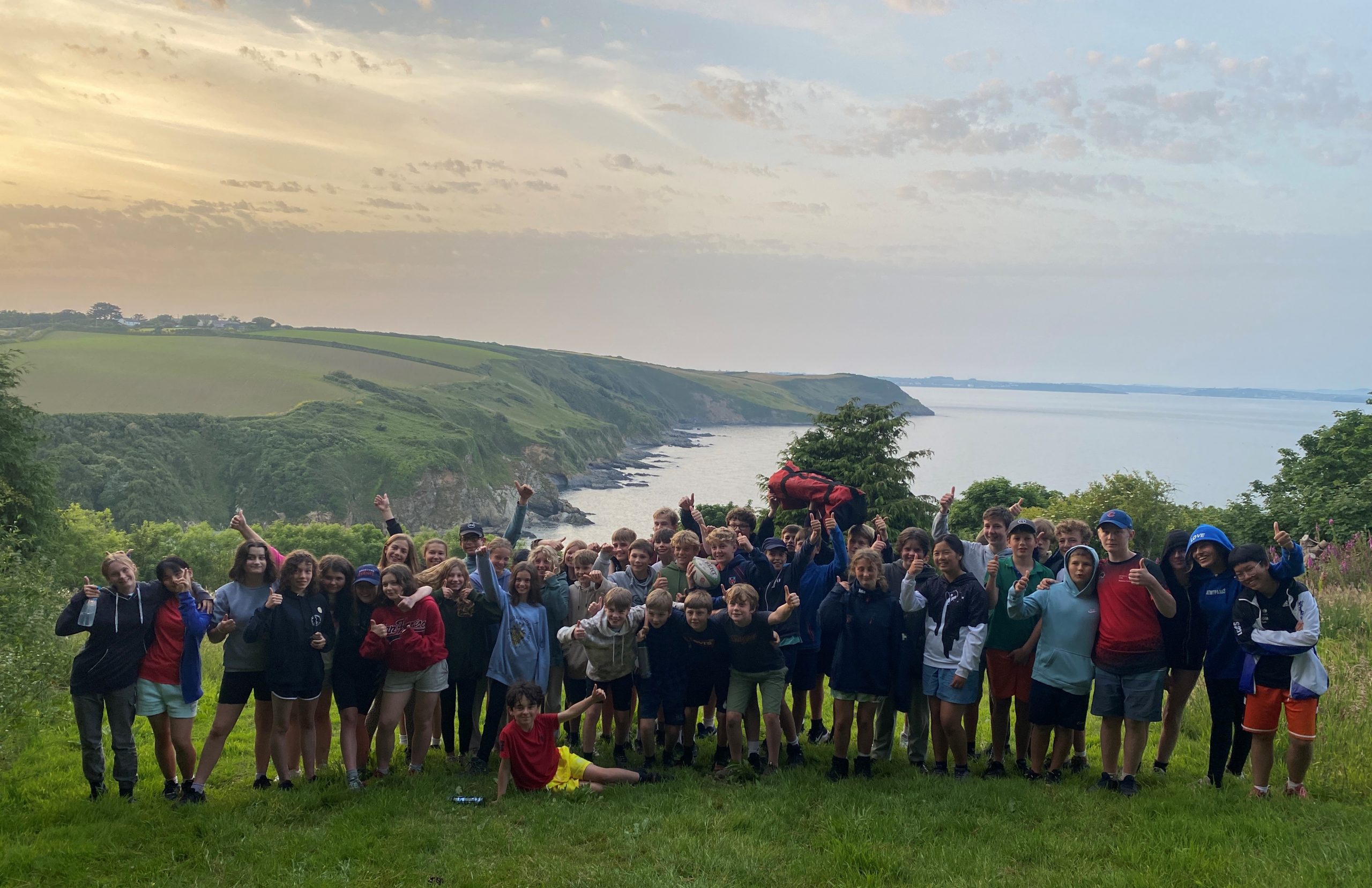 The whole group of students with the sea behind them