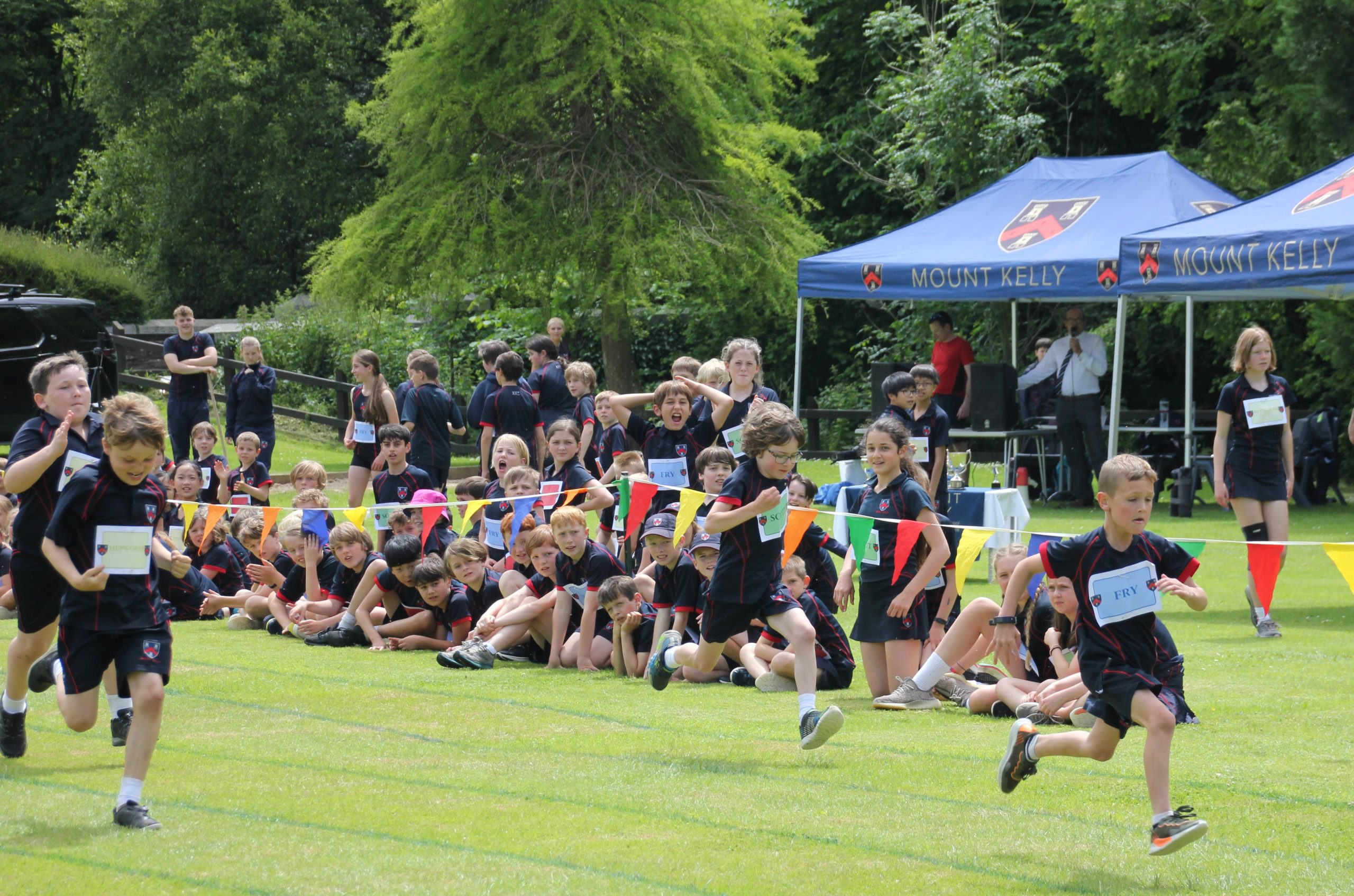 Students running across the track for sports day