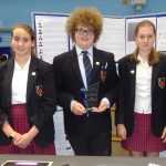 5 students with one holding a trophy