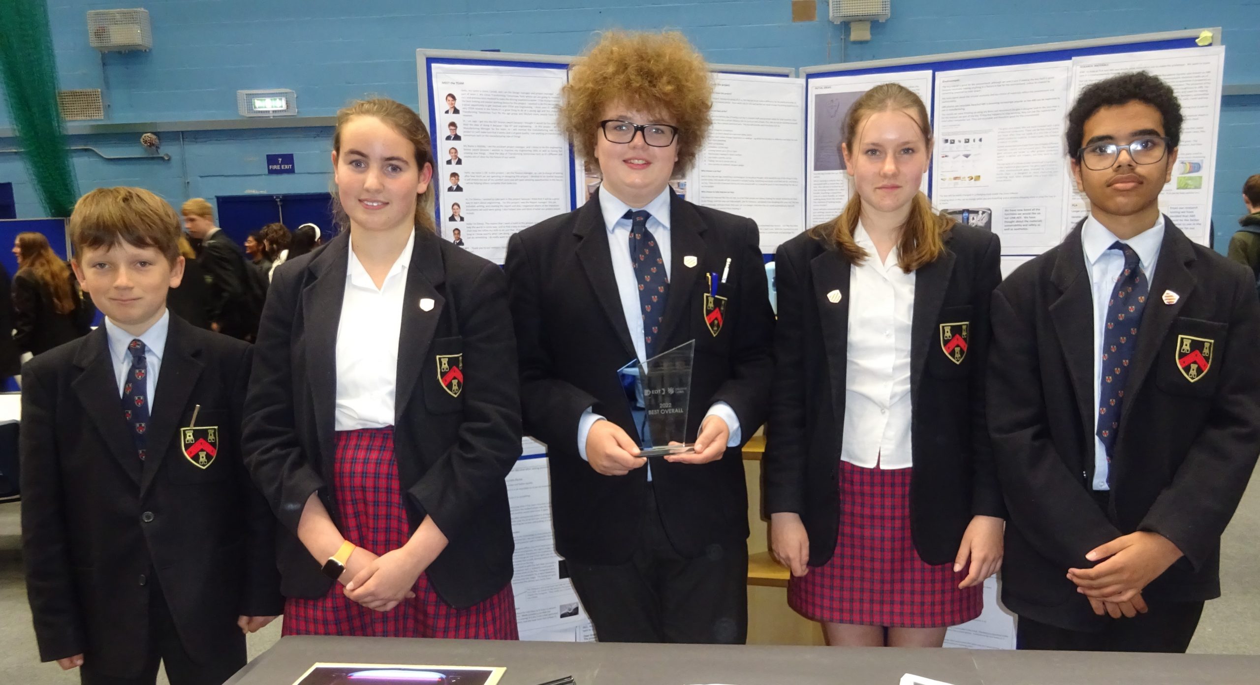 5 students with one holding a trophy