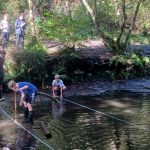 students in the river completing Geography work