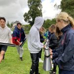 Students holding parts of a pipe