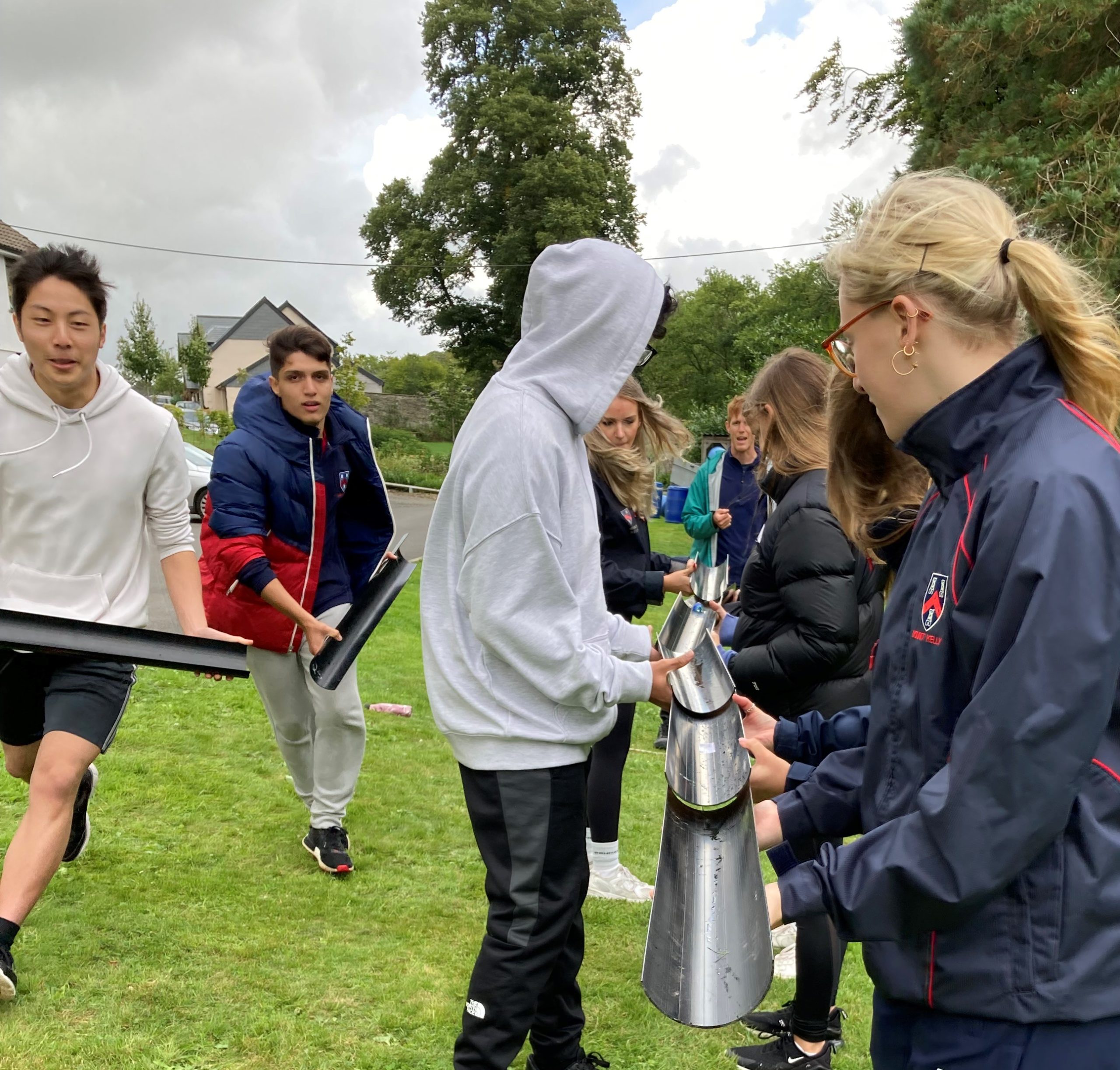 Students holding parts of a pipe