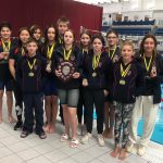 Students with their medals and awards at the swimming pool