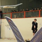 A student on a stage throwing a plane