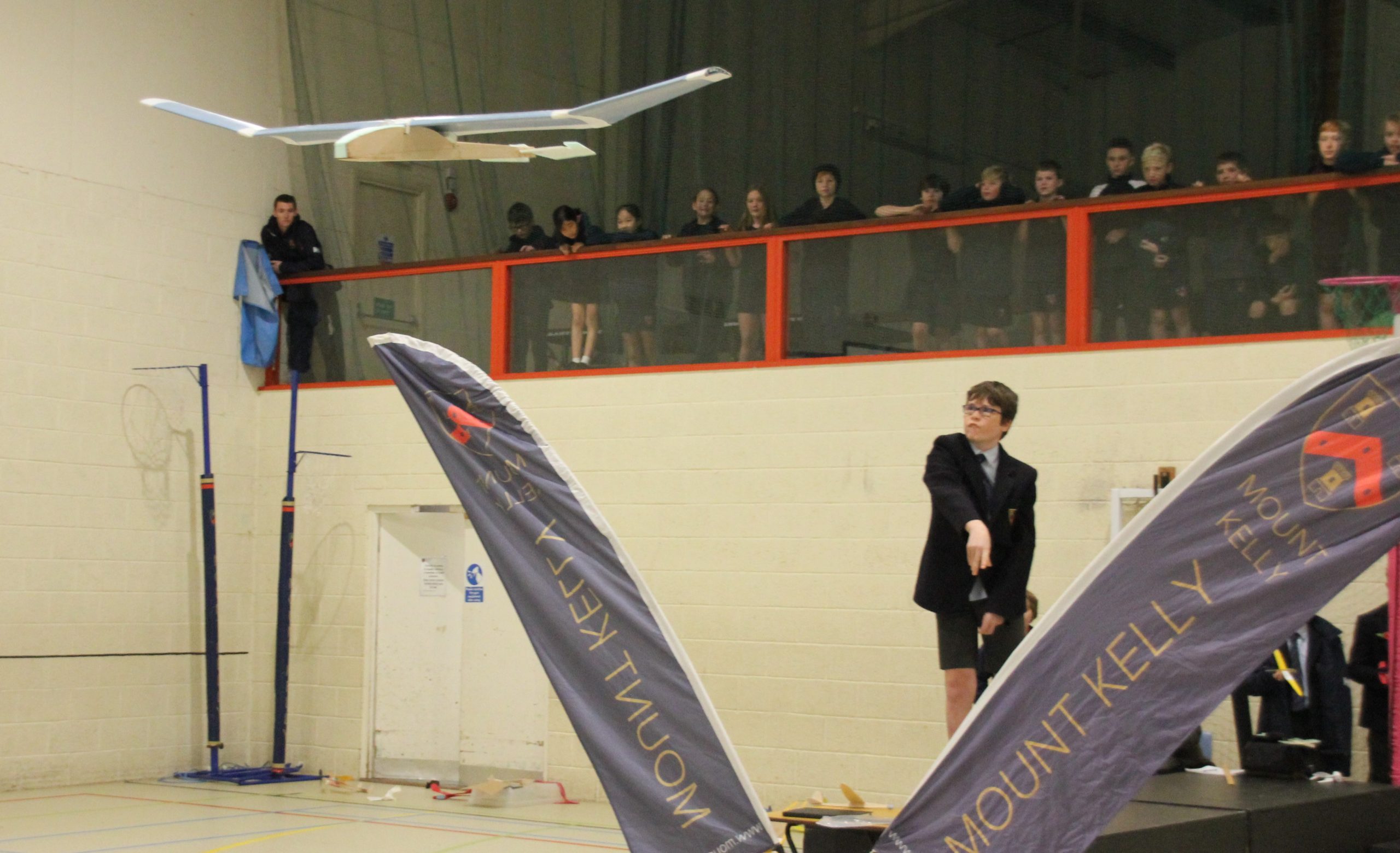 A student on a stage throwing a plane