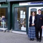 students stood in front of a cafe