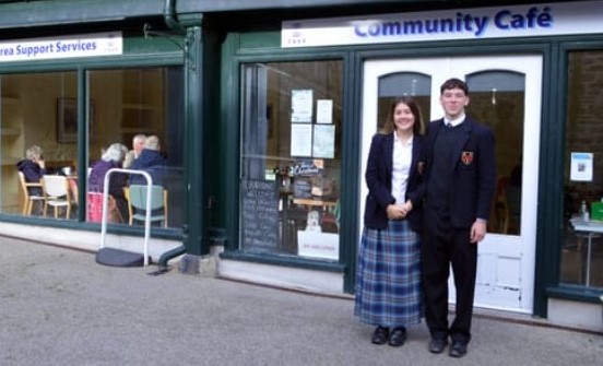 students stood in front of a cafe