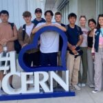 students leaning on a CERN sign