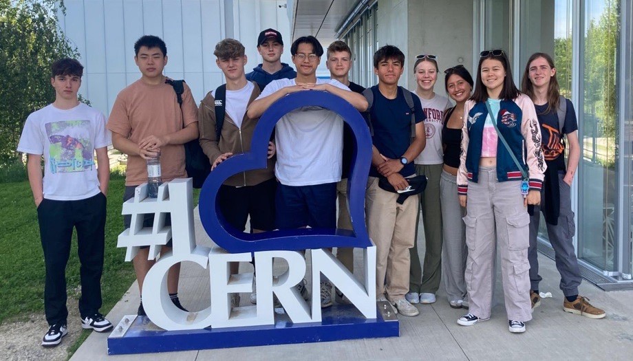 students leaning on a CERN sign