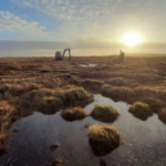 sun rising over water and land