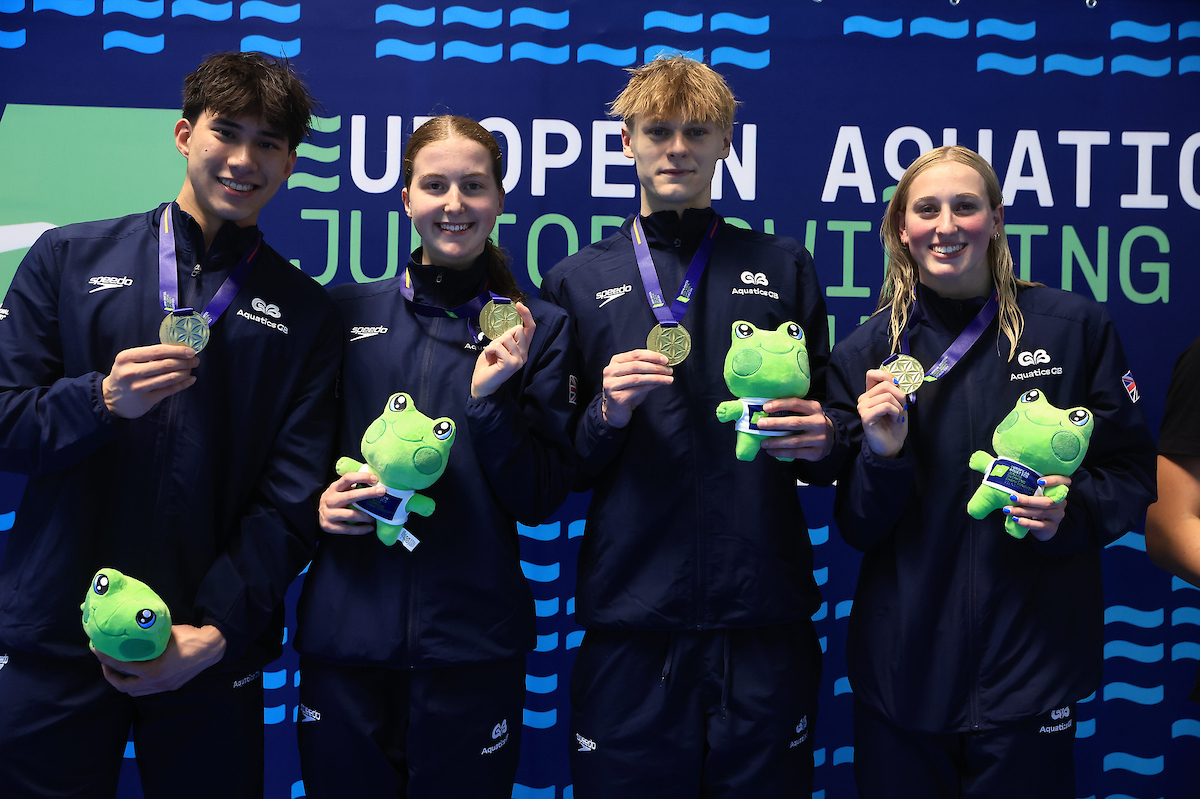 students holding medals and toy frogs