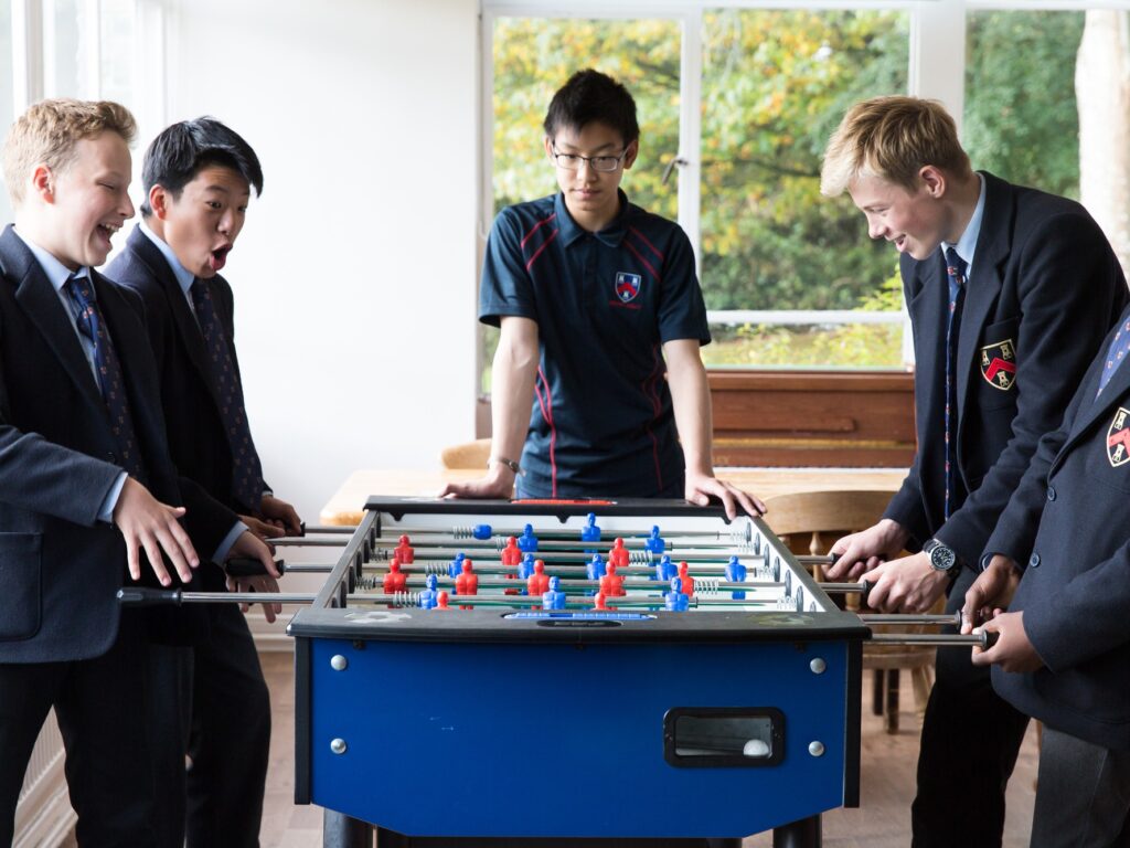 3 students playing foosball