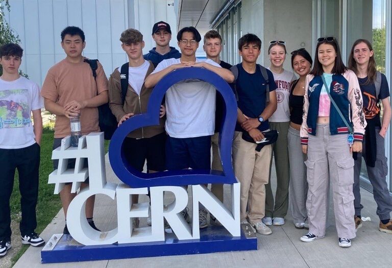 students leaning on a CERN sign